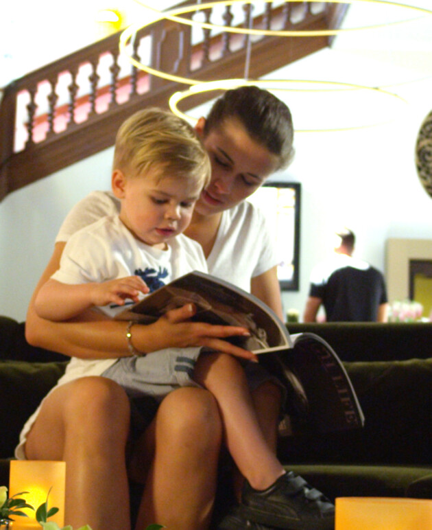 Eine Frau mit einem Kind auf dem Sofa im Lobby Bereich des Schlosshotels.