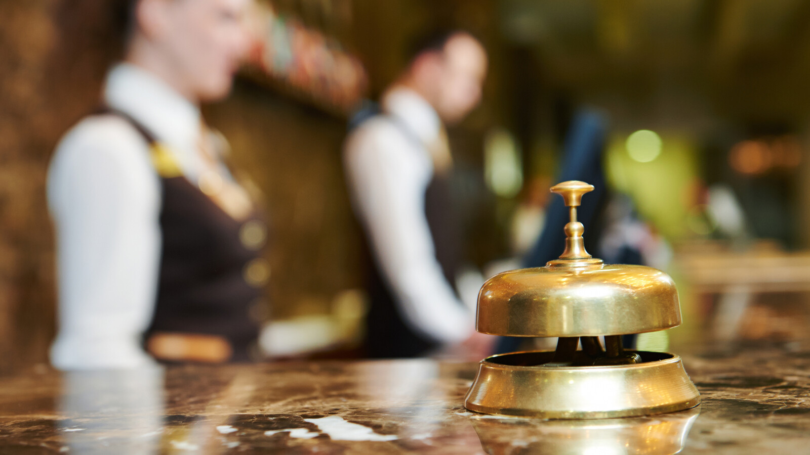 Eine goldene Hotelklingel auf einem Tresen.