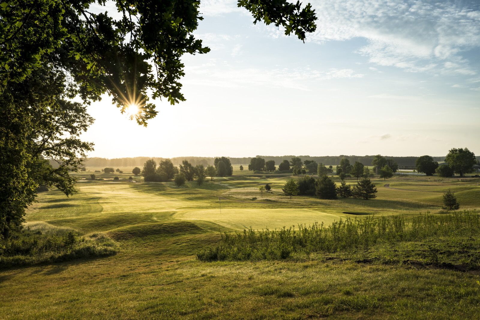 Der Platz des SCHLOSS Hotels Fleesensee Golf im Sonnenuntergang.