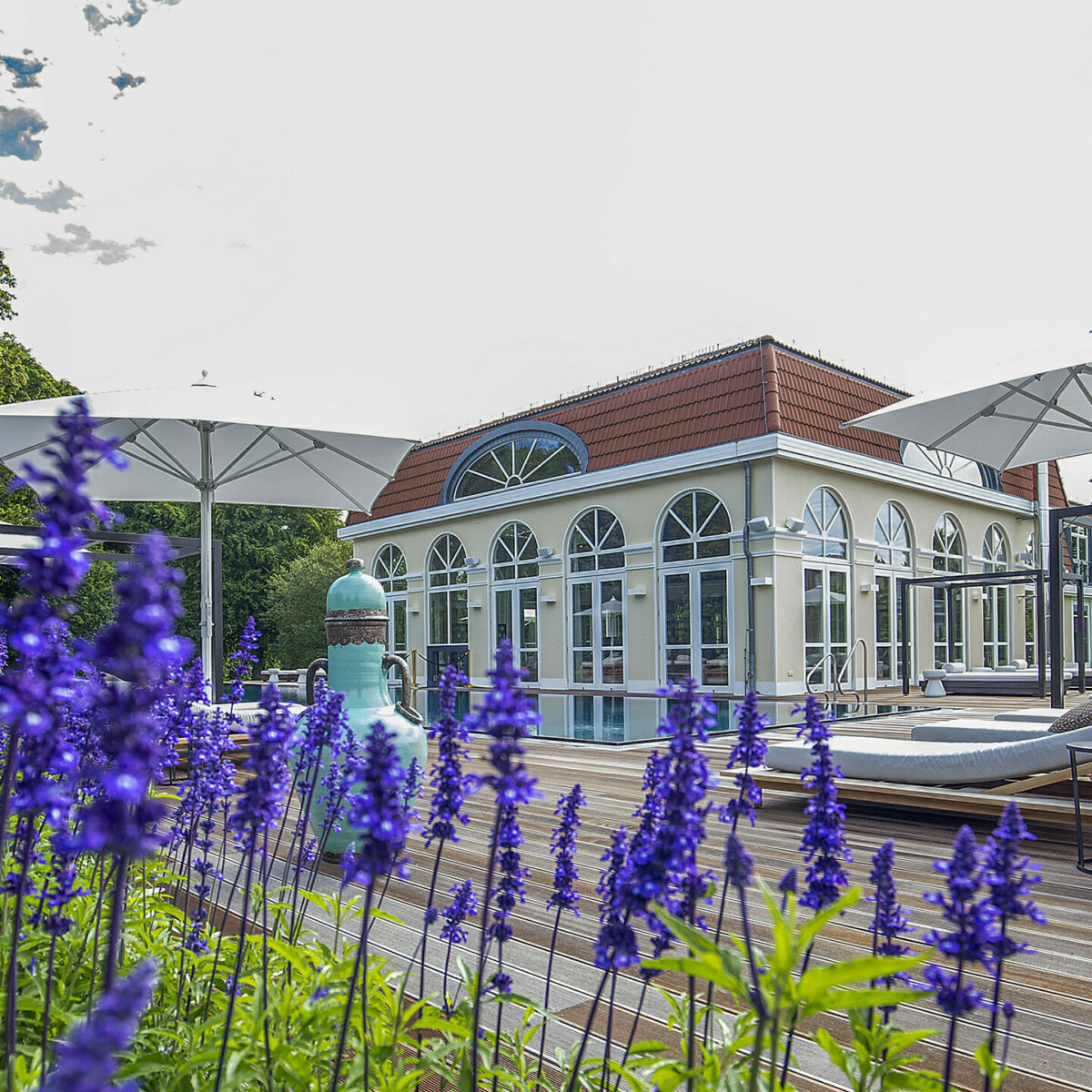 Der Außenbereich des Schloss Spa mit lila Blumen.