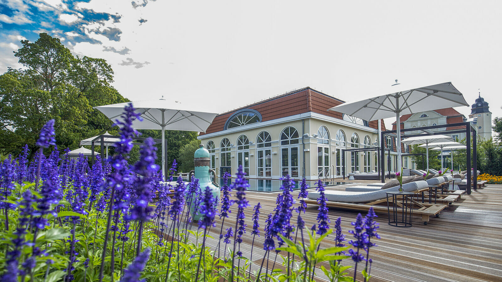 Der Außenbereich des Schloss Spa mit lila Blumen.