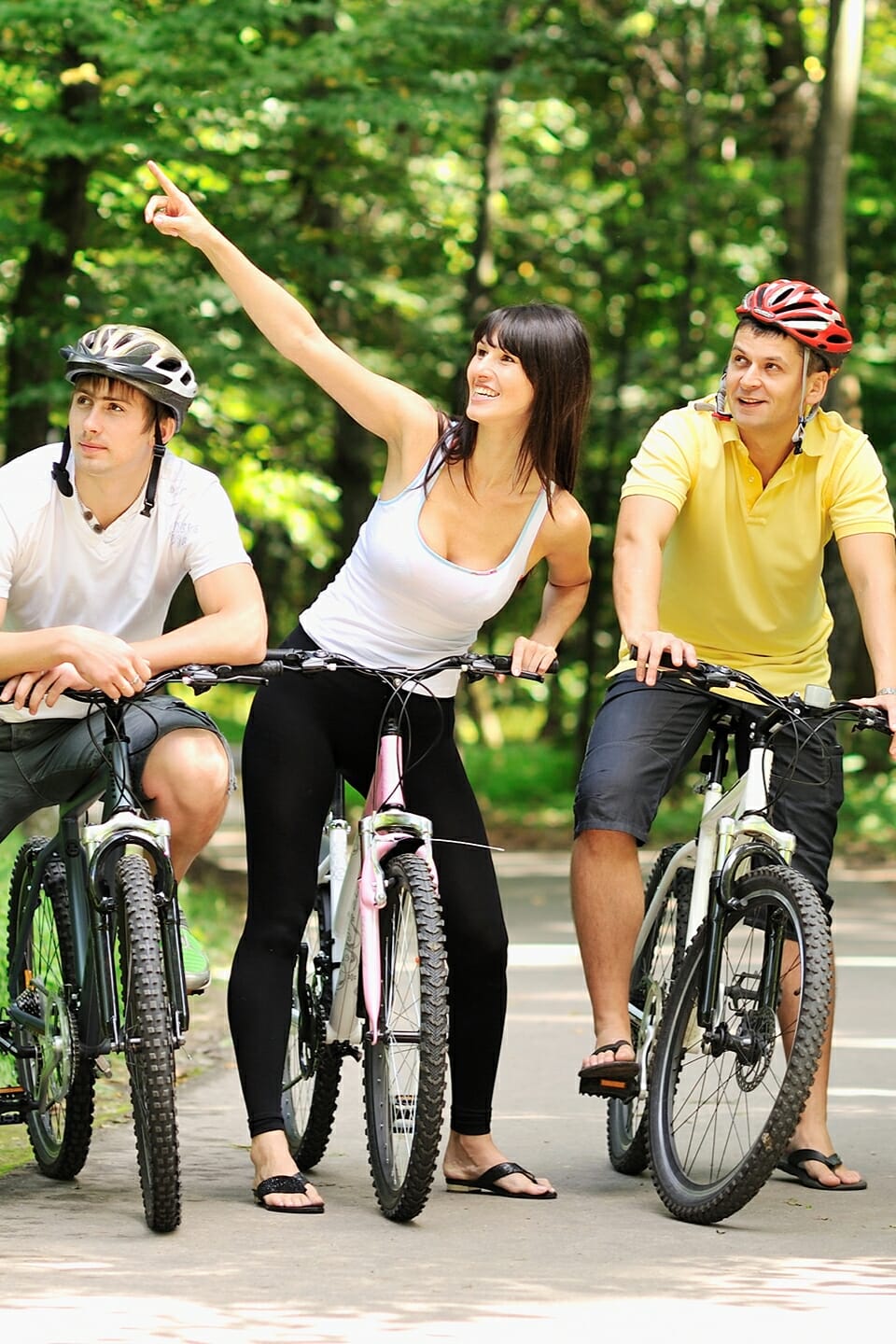 Drei Radfahrer auf einem Weg im Wald.