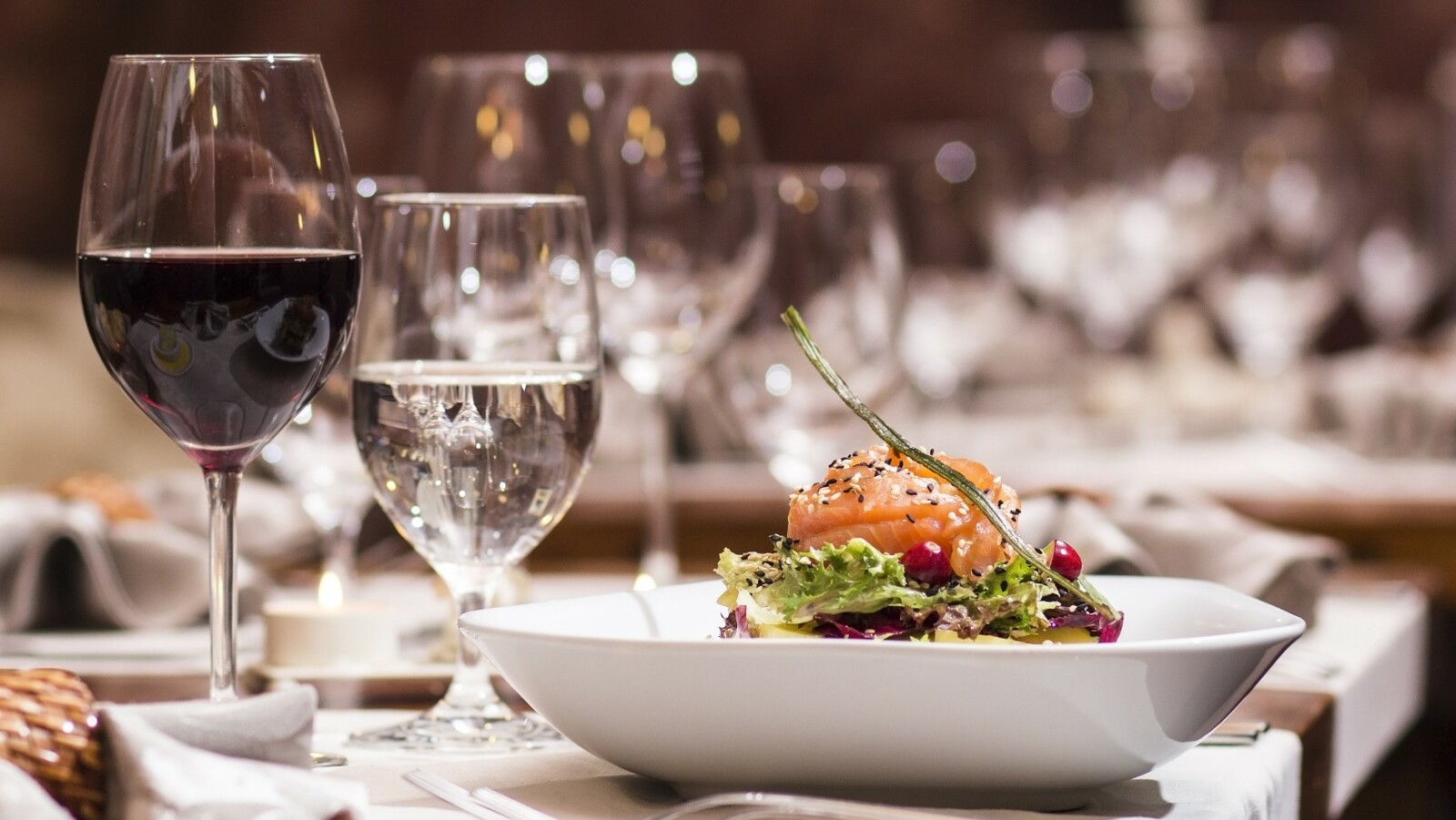 Wein und Wasser neben einem Teller beim Weindinner.