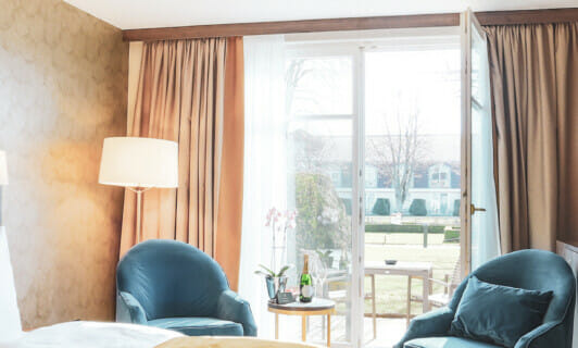Bett und Terrasse im Deluxe Zimmer im Schlosshotel Fleesensee.