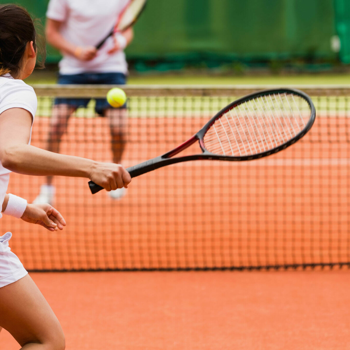 Eine Frau spielen gegen einen Mann Tennis.