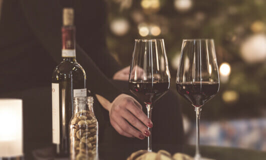 Zwei Gläser mit Rotwein und Nüsse.