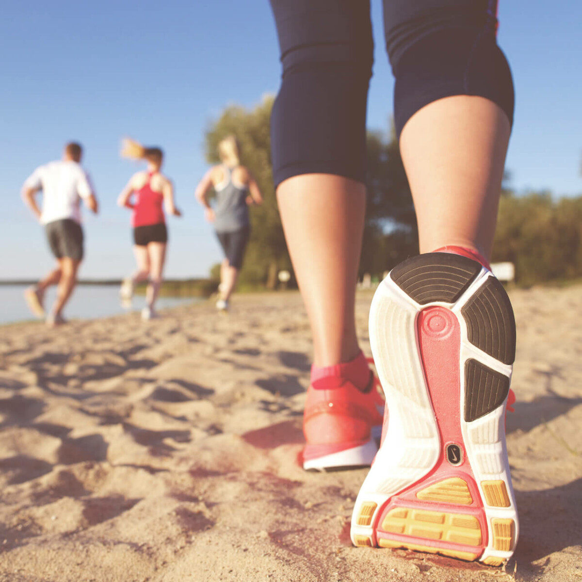 Die Schuhsohle eines Laufschuhs einer Joggerin am Strand.