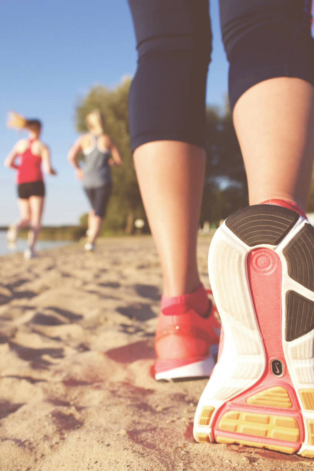 Die Schuhsohle eines Laufschuhs einer Joggerin am Strand.