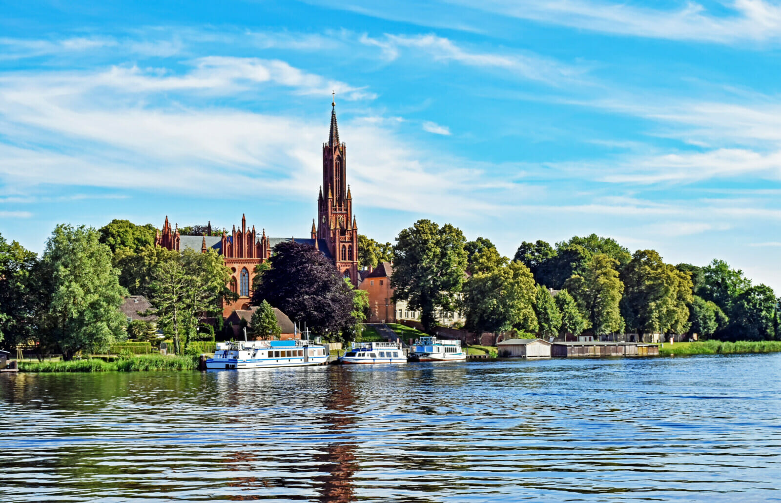 Die Klosterkirche in Malchow mit Ausflugsschiffen.