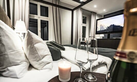 Das Himmelbett im Schloss Zimmer mit Champagnergläsern.