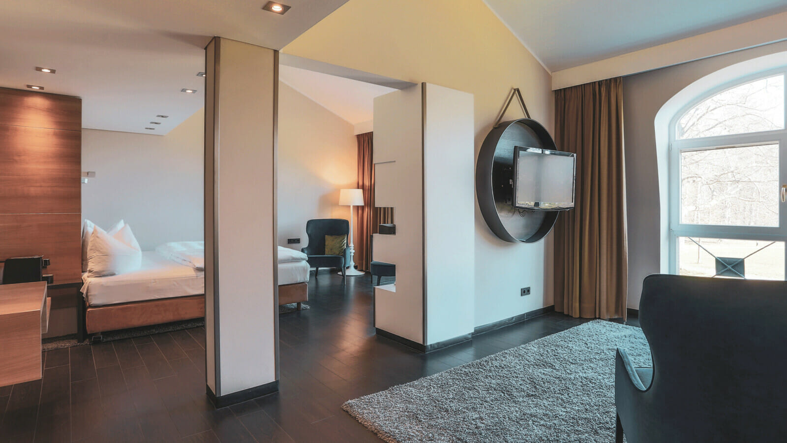Wohnbereich und Schlafbereich in der Park Suite im Schloss Fleesensee.