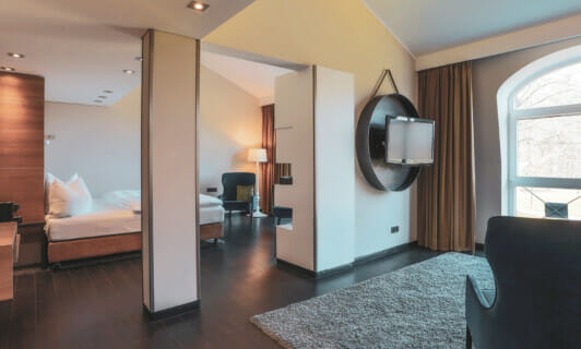 Wohnbereich und Schlafbereich in der Park Suite im Schloss Fleesensee.