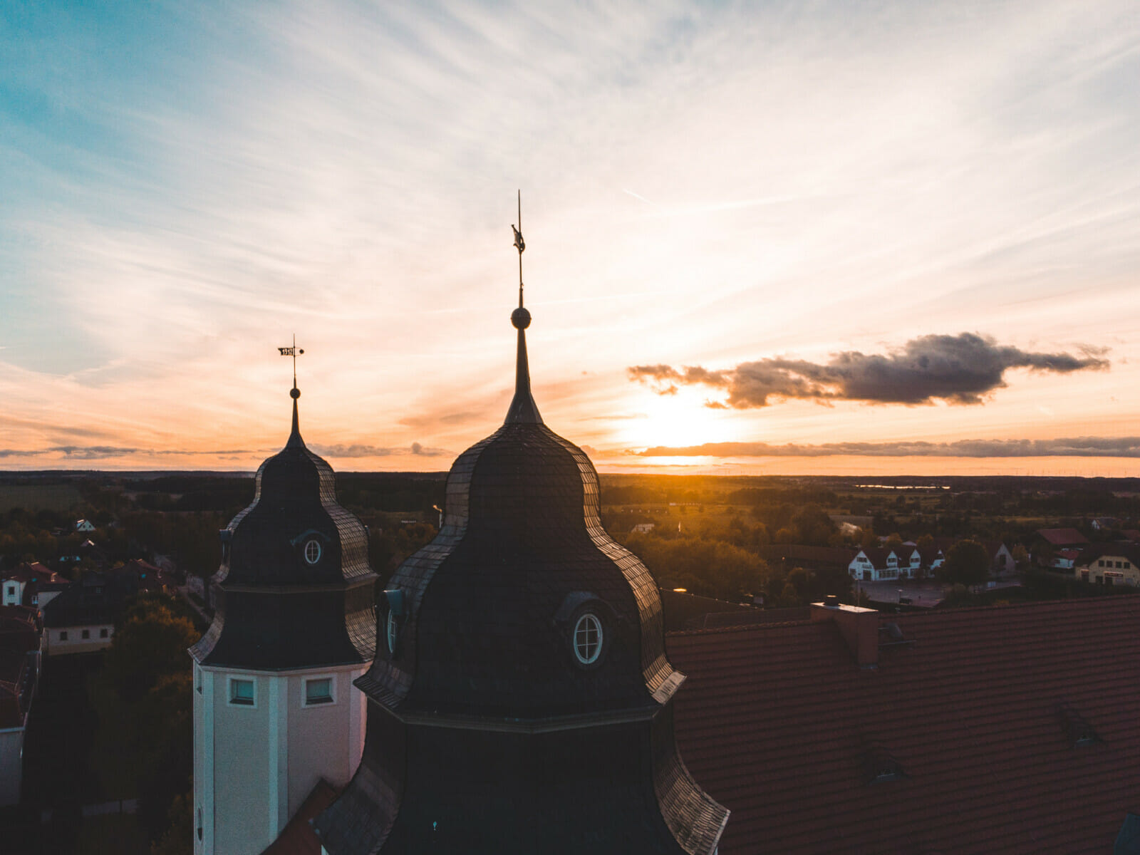 Die Dächer des Schloss Fleesensee im Herbst bei Sonnenuntergang.