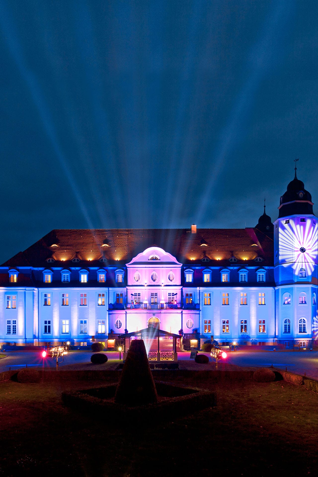 Das Schloss Fleesensee in der Nacht mit bunter Beleuchtung.