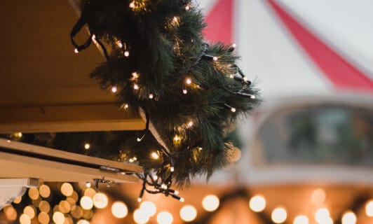 Eine Tannendekoration am Dach einer Bude auf dem Weihnachtsmarkt.