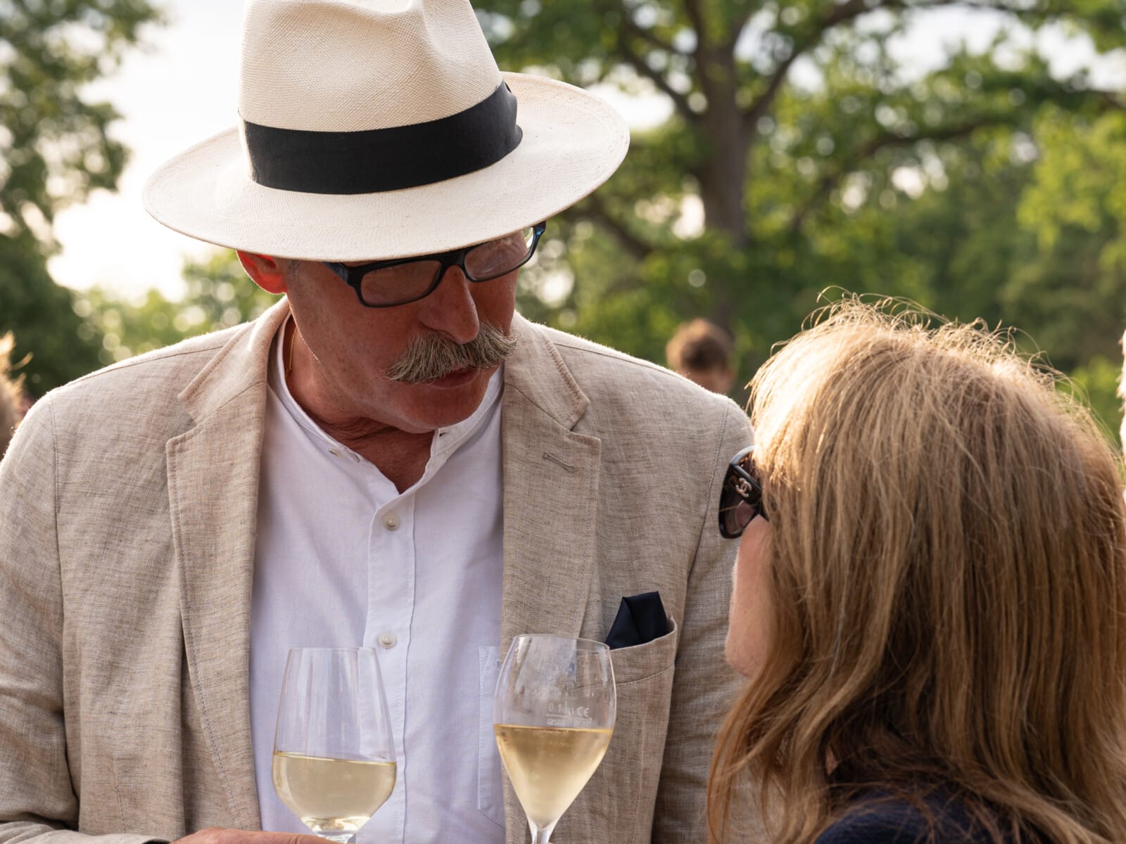 Mann und Frau unterhalten sich mit Wein in der Hand