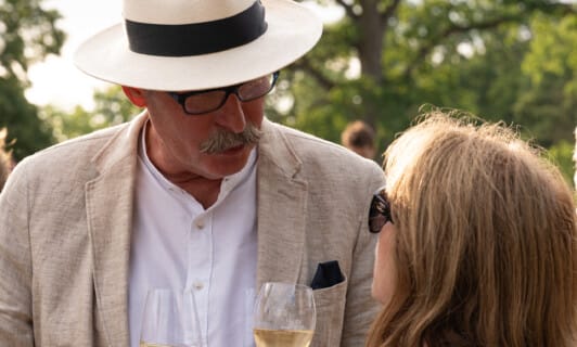 Mann und Frau unterhalten sich mit Wein in der Hand