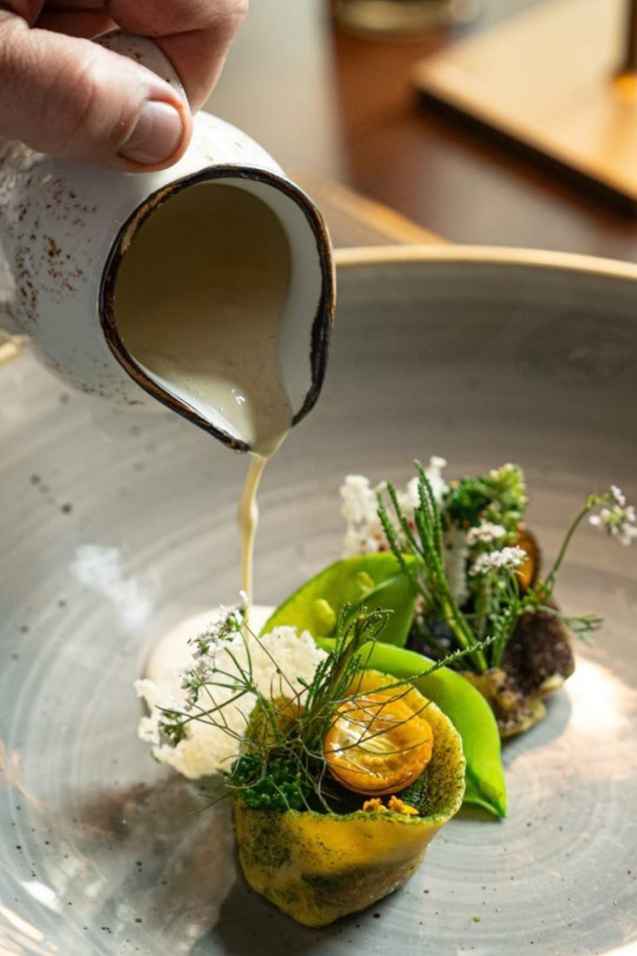 Soße wird auf ein Gourmetgericht gegossen