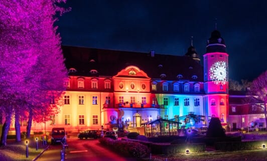 des bunt beleuchtete Schloss Fleesensee bei der Abendveranstaltung Flanierball