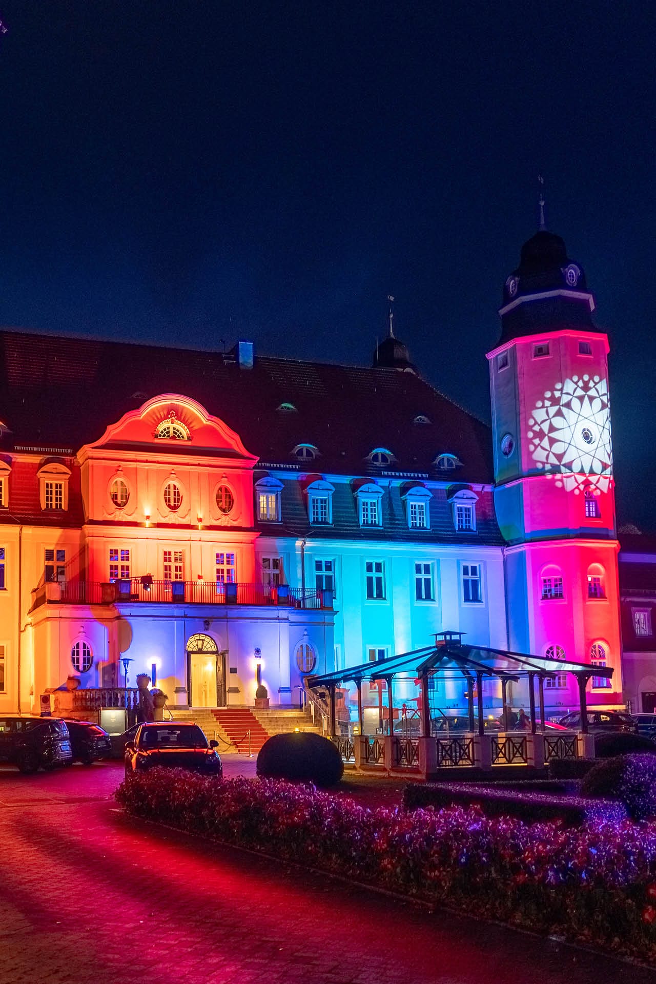 Das bunt beleuchtete Schlosshotel Fleesensee am Abend des Flanierballs